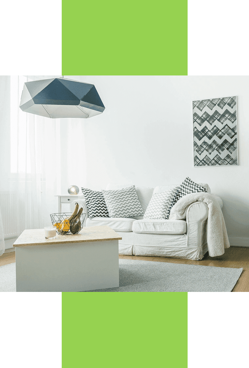 A living room with white furniture and green accents.