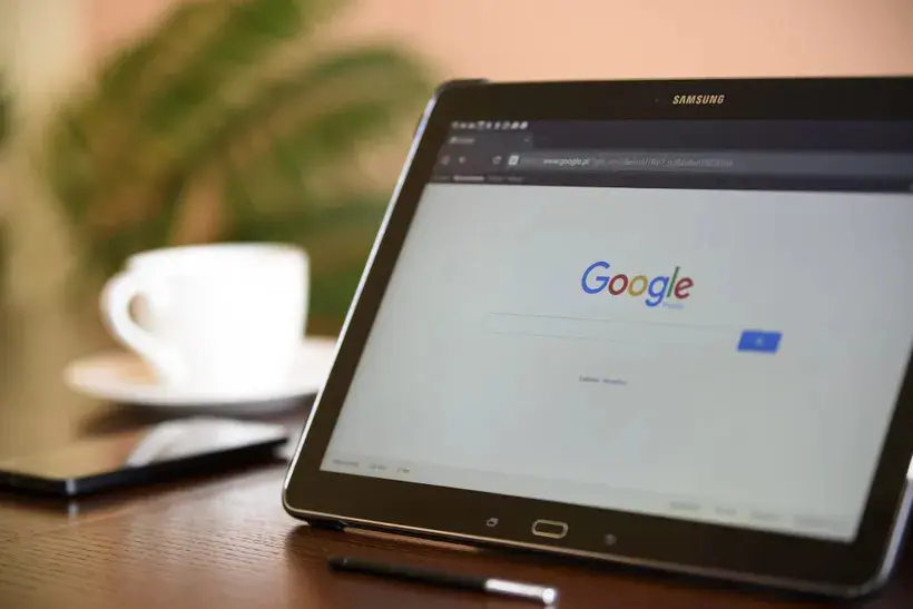 A tablet computer sitting on top of a wooden table.